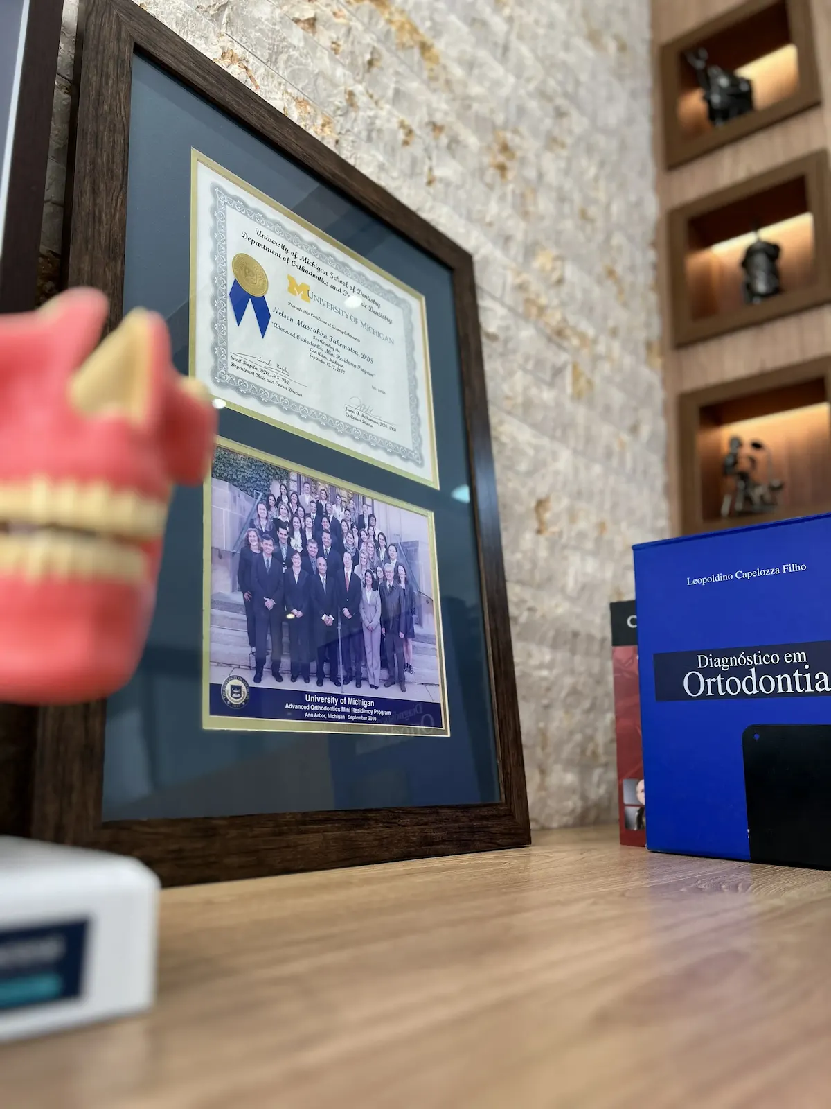 Diploma do Advanced Orthodontics Mini Residency Program — University of Michigan, emoldurado na entrada do consultório do Dr. Nelson Takematsu