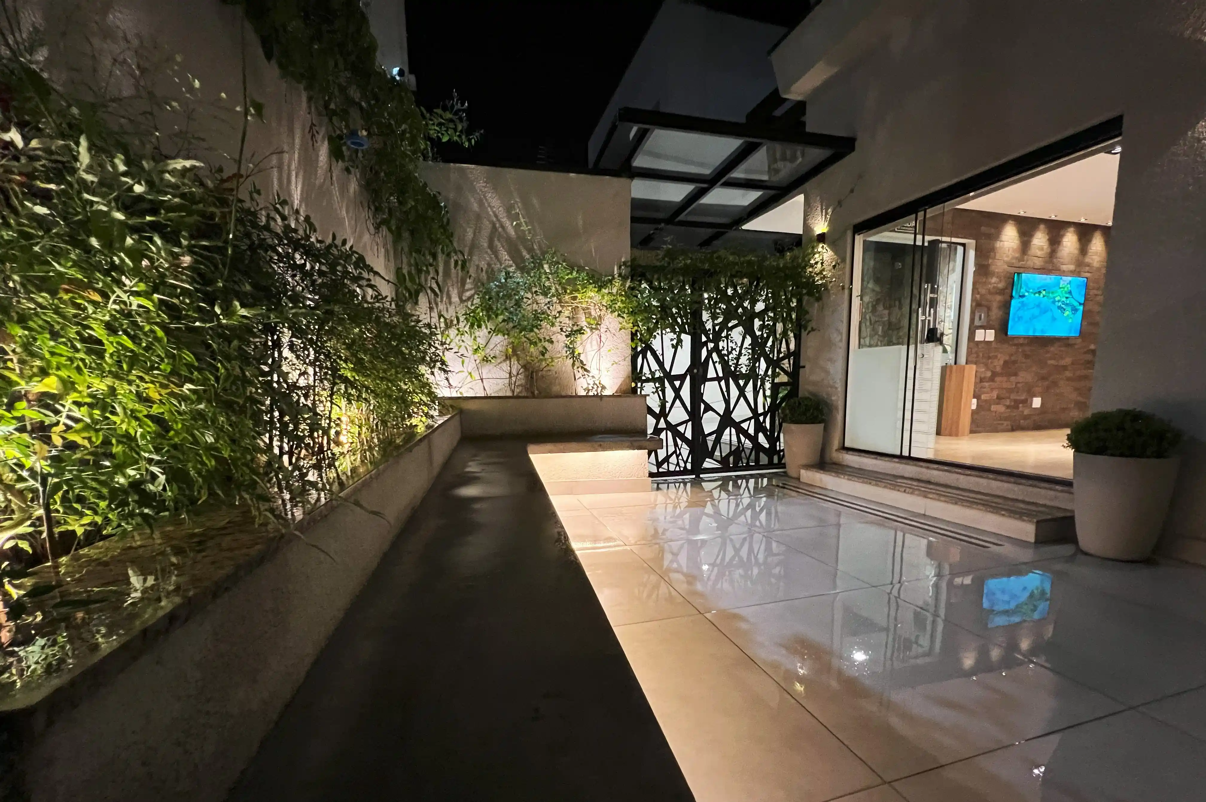 Jardim externo com iluminação noturna — ambiente acolhedor